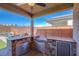 Covered outdoor kitchen boasts stone counter, stainless steel appliances, and a built-in BBQ at 10281 Sequoia Falls Pl, Las Vegas, NV 89149
