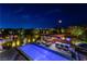 Aerial view of the pool, outdoor kitchen, and dining area, perfect for enjoying the evening ambiance at 10313 Jade Point Dr, Las Vegas, NV 89135