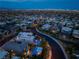 Stunning aerial shot of a home with a backyard pool, outdoor kitchen, mountain views, and city lights at 10313 Jade Point Dr, Las Vegas, NV 89135