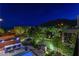 Elevated view of the backyard, pool, outdoor kitchen, landscaping, and surrounding city lights at 10313 Jade Point Dr, Las Vegas, NV 89135