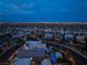 Spectacular aerial view of the neighborhood, featuring city lights, mountain views, and beautifully landscaped yards at 10313 Jade Point Dr, Las Vegas, NV 89135