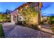 An upscale home showcasing a covered patio, hot tub, outdoor kitchen and luxurious stone tile backyard at 10313 Jade Point Dr, Las Vegas, NV 89135
