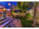 A cozy backyard featuring outdoor dining, lounge areas, an umbrella, and a landscaped garden at 10313 Jade Point Dr, Las Vegas, NV 89135