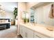 Bright bathroom featuring a large mirror, a white vanity, and access to the main bedroom at 10313 Jade Point Dr, Las Vegas, NV 89135