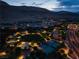 Dusk aerial showcases tennis courts and a neighborhood park with mountain views at 10313 Jade Point Dr, Las Vegas, NV 89135