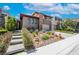 Beautiful modern home featuring stone accents, desert landscaping, and a private two-car garage at 10313 Jade Point Dr, Las Vegas, NV 89135
