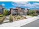 Contemporary home with a three-car garage, stone accents, desert landscaping, and a stylish entryway at 10313 Jade Point Dr, Las Vegas, NV 89135
