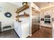 A spacious kitchen area boasts white cabinets, floating shelves, and a stainless steel refrigerator at 10313 Jade Point Dr, Las Vegas, NV 89135