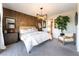 Spacious main bedroom with a wood accent wall, contemporary lighting, and plush rug at 10313 Jade Point Dr, Las Vegas, NV 89135