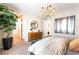 Bright main bedroom boasts a stylish chandelier, modern decor, and ensuite bath access at 10313 Jade Point Dr, Las Vegas, NV 89135