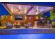 Entertainer's dream with an outdoor kitchen, lounge area, tv, fire pit and seating under a covered patio at 10313 Jade Point Dr, Las Vegas, NV 89135