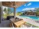 Inviting outdoor space features a patio, dining table, pool, hot tub, and bar with a TV at 10313 Jade Point Dr, Las Vegas, NV 89135