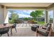 Covered patio overlooking backyard complete with a fire pit, hot tub, bench, and desert landscaping at 11813 Pippa Ave, Las Vegas, NV 89138
