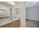 Bathroom boasts a long vanity with quartz counters, a large mirror, modern lighting, and hardwood floors leading to the bedroom at 1324 European Dr, Henderson, NV 89052