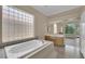 Bathroom featuring soaking tub, natural light, walk-in shower, and dual sink vanity at 1324 European Dr, Henderson, NV 89052