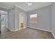 A spacious bedroom with hardwood floors, neutral walls, and a doorway leading to an arched entryway to the bathroom at 1324 European Dr, Henderson, NV 89052
