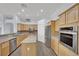 Modern kitchen featuring stainless steel appliances, wooden cabinets, and granite countertops at 1324 European Dr, Henderson, NV 89052