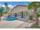 Backyard oasis boasts a sparkling pool with a patio, surrounded by mature trees and lush landscaping at 1324 European Dr, Henderson, NV 89052