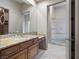Bathroom features double sinks, granite counters, wooden vanity, walk-in closet, and glass shower at 1665 Liege Dr, Henderson, NV 89012