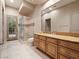 Bathroom with double sinks, wood vanity, glass enclosed shower, and access to the outdoors at 1665 Liege Dr, Henderson, NV 89012