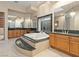 A luxurious primary bathroom features a jetted tub, a vanity and a well-organized closet at 1665 Liege Dr, Henderson, NV 89012