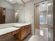 Bathroom features wooden vanity with stone countertop, and a walk-in closet and shower at 1665 Liege Dr, Henderson, NV 89012