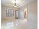 Bright bedroom features tile floors, shuttered windows, modern chandelier, and bathroom access at 1665 Liege Dr, Henderson, NV 89012