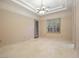 Bedroom with tile floors, modern chandelier, shuttered windows, and ensuite bathroom at 1665 Liege Dr, Henderson, NV 89012