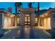 Elegant home entrance with an ornate front door, well-lit porch, and attached two-car garages at 1665 Liege Dr, Henderson, NV 89012