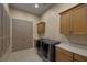 Laundry room featuring washer, dryer, sink, cabinets and shuttered window at 1665 Liege Dr, Henderson, NV 89012