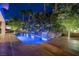 Beautifully lit swimming pool with a waterfall feature, surrounded by lush landscaping at 1665 Liege Dr, Henderson, NV 89012