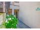Building entrance with a walkway surrounded by white flowers and green foliage at 1830 N Buffalo Dr # 1031, Las Vegas, NV 89128
