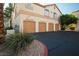 Exterior of a multi-unit building featuring garage doors and well-maintained landscaping at 1830 N Buffalo Dr # 1031, Las Vegas, NV 89128