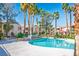 Community pool surrounded by lush landscaping and multi-story buildings at 1830 N Buffalo Dr # 1031, Las Vegas, NV 89128