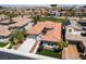 Aerial view of the home's tile roof and a neighborhood near a golf course with city views in the distance at 2080 Orchard Mist St, Las Vegas, NV 89135