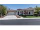 Charming single-story home featuring a tile roof, neutral stucco, arched entry, and well-manicured landscaping at 2080 Orchard Mist St, Las Vegas, NV 89135