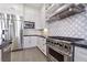The gourmet kitchen is equipped with stainless steel appliances, custom backsplash and modern countertops at 2080 Orchard Mist St, Las Vegas, NV 89135