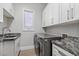 Well-organized laundry room with modern washer/dryer, granite countertops, and ample cabinet space at 2080 Orchard Mist St, Las Vegas, NV 89135