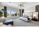 Bright main bedroom with a large bed, seating area and a lovely view of the home's exterior at 2080 Orchard Mist St, Las Vegas, NV 89135