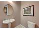 Small bathroom with a pedestal sink, toilet, and an art print on the wall at 2764 Leys Burnett Ave, Henderson, NV 89044