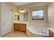 Bright bathroom featuring a soaking tub under a window, a sink, and tiled floors at 2764 Leys Burnett Ave, Henderson, NV 89044