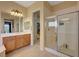 Well-lit bathroom featuring a sink with a large mirror and a glass-enclosed shower at 2764 Leys Burnett Ave, Henderson, NV 89044