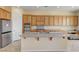 Bright kitchen featuring an island, stainless steel appliances, and wood cabinets at 2764 Leys Burnett Ave, Henderson, NV 89044