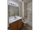 Bright bathroom with tile floor, wood vanity, marble countertop, framed mirror, and shower-tub combo at 3029 Frigate Way, North Las Vegas, NV 89084