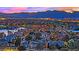 Nighttime aerial view of a residential neighborhood with tree-lined streets showcasing a vibrant cityscape beyond at 3080 Yankee Clipper Dr, Las Vegas, NV 89117