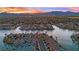 Beautiful sunset view over a waterfront community showing canal homes, palm trees, and distant mountains at 3080 Yankee Clipper Dr, Las Vegas, NV 89117