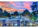 An elevated view showcases rooftops and a distant city skyline framed by trees under a vibrant, colorful sky at 3080 Yankee Clipper Dr, Las Vegas, NV 89117