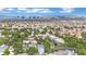 Sprawling neighborhood aerial view showcasing diverse residences and lush greenery against a city skyline backdrop at 3080 Yankee Clipper Dr, Las Vegas, NV 89117