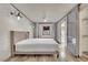 Bright bedroom featuring a white brick wall, light fixture, and a gray bedframe with white bedding at 3080 Yankee Clipper Dr, Las Vegas, NV 89117