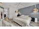 Spacious bedroom featuring light wood floors, gray walls, decorative lighting, and a sleek modern aesthetic at 3080 Yankee Clipper Dr, Las Vegas, NV 89117